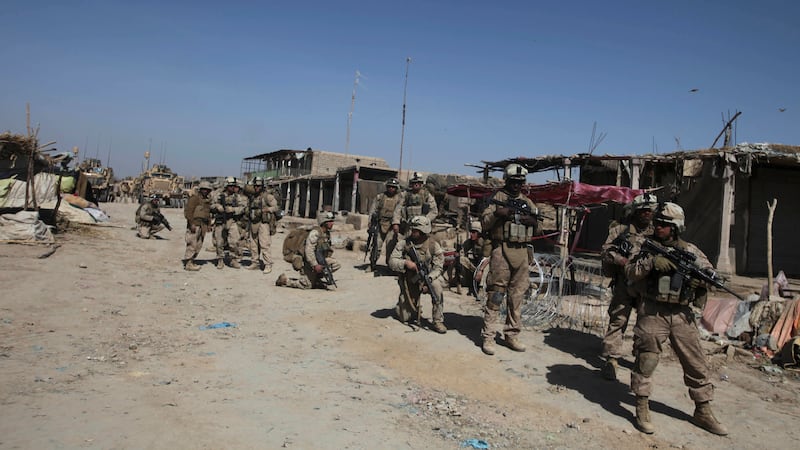 U.S. Marines with NATO forces patrol inwld a deserted market of Marjah, Afghanistan,...